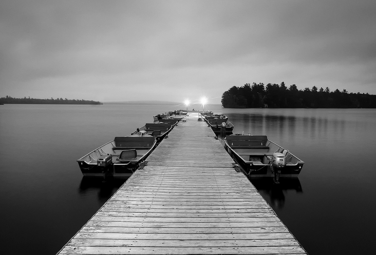 black and white image of dock and boats